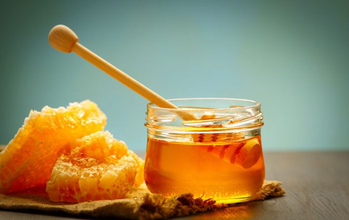 Honey pot and raw honey on a table