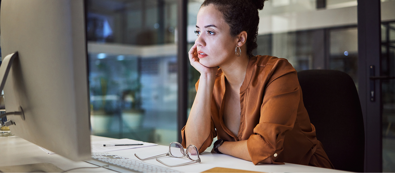 MCS Social Blog – Why Validation Still Fails and What Regulators Look For 01 A woman sitting at a desk looking at a screen in deep in thought.