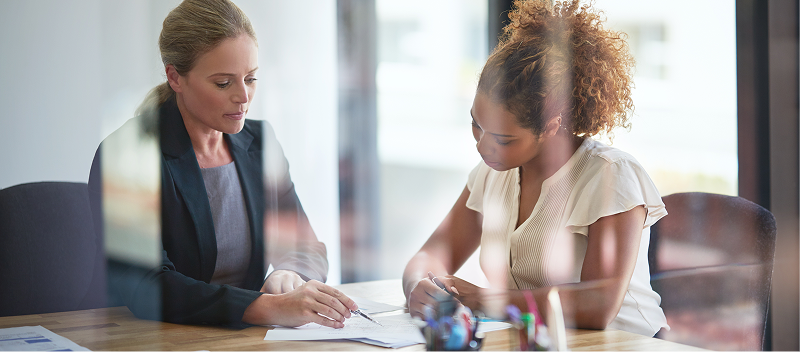 Two people in discussion over paperwork.